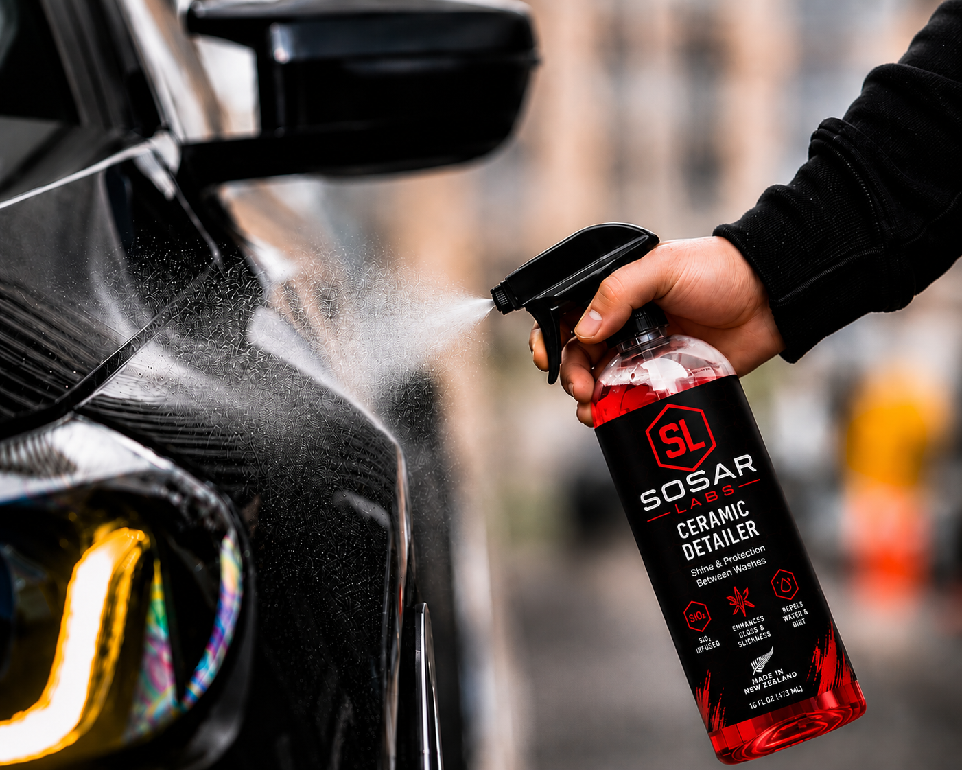 SOSAR LABS SS7 Ceramic Detailer being sprayed onto a black car panel